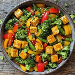 - Tofu and Vegetables - 1 block firm tofu, drained and pressed - 1 red bell pepper, sliced - 1 yellow bell pepper, sliced - 1 cup broccoli florets - 1 cup sugar snap peas, trimmed - 1 medium carrot, julienned - 3 cloves garlic, minced - 1-inch piece ginger, grated - Sauces and Seasonings - 1 tablespoon cornstarch - 2 tablespoons sesame oil - 3 tablespoons soy sauce - 1 tablespoon maple syrup or honey - 1 tablespoon rice vinegar - 1 teaspoon sriracha (optional, for heat) - Sesame Seeds - Chopped green onions In this dish, I focus on fresh and colorful veggies, along with firm tofu. Tofu gives the stir-fry protein, while the vegetables add crunch and flavor. I like to use a mix of bell peppers, broccoli, and snap peas. This adds both color and texture to the meal. For sauces and seasonings, I often go with soy sauce for saltiness. Maple syrup or honey adds a bit of sweetness, which balances the salty flavor. Sesame oil gives a nutty taste that enhances the dish. If you want some heat, add sriracha. Don't skip the garnishes! Toasted sesame seeds and green onions make the dish look nice and taste even better. They add a fun crunch and fresh flavor. You can find the Full Recipe to make this delicious vegetable stir-fry with tofu. Enjoy cooking! Start by cutting the pressed tofu into bite-sized cubes. This size helps the tofu cook evenly. Then, toss the tofu cubes in cornstarch. Make sure each piece gets a nice coating. This helps create a crispy texture when you cook it. Next, heat 1 tablespoon of sesame oil in a large non-stick skillet or wok over medium-high heat. Once the oil is hot, add the tofu cubes in a single layer. Cook the tofu until it turns golden brown and crispy on all sides, about 8-10 minutes. Once crispy, remove the tofu from the skillet and set it aside. In the same skillet, add the remaining sesame oil. Once hot, add the minced garlic and grated ginger. Sauté them for about 30 seconds until they smell great. Now, add the sliced bell peppers, broccoli florets, sugar snap peas, and julienned carrots to the skillet. Stir-fry these colorful veggies for about 4-5 minutes. You want them to be bright and slightly tender but still crisp. In a small bowl, mix together soy sauce, maple syrup or honey, rice vinegar, and sriracha if you want some heat. Pour this sauce over the stir-fried veggies. Finally, return the crispy tofu to the skillet. Gently toss everything together, making sure the tofu and vegetables are well coated with the sauce. Cook for another 2-3 minutes. Remove from heat and let it rest for a minute before serving. You can find the full recipe for this dish in the main article. Enjoy your colorful and tasty meal! To make crispy tofu, start by pressing it well. Remove excess water by placing a heavy object on it. After pressing, cut the tofu into cubes. Next, coat each cube with cornstarch. This helps create a crispy outer layer. When you fry the tofu, use hot sesame oil. Cook it until golden brown, about 8-10 minutes. This method gives you that wonderful crunch. Choosing the right vegetables makes a big difference in your stir-fry. I love using seasonal produce for the best flavor. Bell peppers, broccoli, and snap peas are my favorites. They add color and crunch. You can also try carrots, zucchini, or even mushrooms. Mix a variety of colors for a fun look. Each vegetable cooks at its own pace. Keep them crisp by not overcooking. Sauces can change the whole dish. Start with soy sauce for a savory base. Then, add maple syrup or honey for sweetness. Rice vinegar brings a tangy note. If you like it spicy, add sriracha. You can adjust these amounts to match your taste. Experiment until you find your perfect mix. For a richer flavor, try garlic or ginger in the sauce. This will take your stir-fry to the next level. Remember, every ingredient counts for a great meal! For the full recipe, check out the Rainbow Vegetable Stir-Fry with Tofu 🥦. {{image_2}} If you want to change up the protein, try tempeh or chickpeas. Tempeh has a nutty taste and a firm texture. It soaks up flavors well. Simply cut it into cubes like tofu and cook it the same way. Chickpeas add a nice bite and are great for a quick meal. Use canned chickpeas for ease; just rinse and add them to your stir-fry. Both options offer a great protein boost and work well with the sauce. You can use different vegetables based on what you have. Seasonal and local veggies add freshness and flavor. In fall, use Brussels sprouts or squash. In summer, add zucchini or eggplant. Feel free to mix and match what you enjoy. Just remember to cut them into similar sizes for even cooking. This way, your stir-fry stays colorful and vibrant. Want to kick up the heat? Add more sriracha or some chili flakes. For a sweeter touch, include pineapple chunks or extra maple syrup. Sweet and spicy flavors blend nicely. You can also try adding a dash of hoisin sauce for extra depth. These little tweaks can make your stir-fry unique every time you cook it. Store your vegetable stir-fry with tofu in a sealed container. Let it cool to room temperature first. Place it in the fridge within two hours of cooking. This keeps it fresh and safe to eat. It will stay good for up to three days. You can reheat your stir-fry in two ways: the microwave or stovetop. For the microwave, place your stir-fry in a bowl. Cover it with a damp paper towel. Heat it for about one to two minutes. Stir halfway to heat evenly. If using the stovetop, put the stir-fry in a pan over medium heat. Add a splash of water or oil to help steam it. Stir often until it's hot. To freeze your stir-fry, let it cool first. Use a freezer-safe container or bag. Remove as much air as possible. Label it with the date. It will last up to three months. When ready to eat, thaw it in the fridge overnight before reheating. This keeps the flavors and textures nice. Enjoy your meal later! For the full recipe, check out the Rainbow Vegetable Stir-Fry with Tofu. Yes, you can prepare this stir-fry in advance. Here’s how: - Cook the tofu and vegetables as directed but stop before adding the sauce. - Cool the stir-fry completely before storing it in an airtight container. - Refrigerate for up to three days. - When ready to eat, reheat in a pan and add the sauce. This helps keep the flavors fresh! Tofu can become soggy if not handled well. Here are some tips: - Use firm tofu; it holds its shape better. - Press the tofu to remove excess water before cooking. - Coat the tofu in cornstarch to create a crispy layer. - Cook in hot oil until golden brown. This gives it a nice crunch! You can pair this stir-fry with many sides: - Serve over rice or quinoa for a filling meal. - Add noodles for a fun twist. - Top with nuts for added crunch and flavor. - Serve with a side salad for extra veggies. Each option adds a new layer of taste to your meal! For a complete guide, check out the Full Recipe. In this post, I covered key ingredients, cooking steps, and helpful tips for making a tasty stir-fry. You learned how to prepare crispy tofu, stir-fry veggies, and customize flavors. Remember to choose fresh ingredients for the best taste. Feel free to swap proteins or veggies based on what you love. With these steps, you can enjoy a delicious dish any time. Cooking stir-fry is easy and fun, so get creative and make it your own!