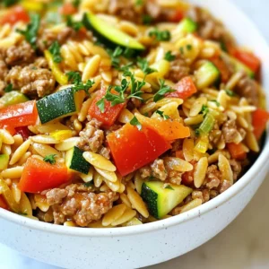 - 1 pound ground turkey - 1 cup orzo pasta - 1 medium onion, diced - 2 cloves garlic, minced - 1 red bell pepper, diced - 1 zucchini, diced The star of this dish is the ground turkey. It is lean and full of flavor. Orzo pasta is like little rice grains but with a pasta twist. The mix of onion, garlic, bell pepper, and zucchini adds color and crunch. These veggies bring a fresh taste to the meal. - 1 teaspoon dried oregano - 1 teaspoon smoked paprika - 2 cups chicken broth Dried oregano gives a nice herbal note. Smoked paprika adds a warm, smoky flavor. Chicken broth is the liquid gold that ties it all together. It makes the orzo creamy and rich as it cooks. - 1 tablespoon lemon juice - Fresh parsley, chopped (for garnish) - Salt and pepper to taste A squeeze of lemon juice brightens the dish. Fresh parsley adds a pop of color and flavor. Adjust salt and pepper to your liking for the perfect taste. This combination of ingredients makes a simple yet delicious meal. {{ingredient_image_1}} Start by dicing the onion, garlic, bell pepper, and zucchini. Use a sharp knife for clean cuts. Next, measure out your spices: oregano and smoked paprika. Pour two cups of chicken broth into a measuring cup. This prep makes cooking easy and quick. Heat two tablespoons of olive oil in a large skillet over medium heat. Add the diced onion. Saut&eacute; it until it turns translucent, about three to four minutes. Then, toss in the minced garlic and diced red bell pepper. Cook for another two minutes until the mix smells great. Now, raise the heat to medium-high. Add the ground turkey next. Use a spatula to break it up as it cooks. Keep cooking until it turns brown and there is no pink left, about five to six minutes. Once browned, stir in the diced zucchini, oregano, smoked paprika, salt, and pepper. Cook for three more minutes. This lets the veggies soften and soak up all those tasty flavors. Now, it&rsquo;s time to combine! Add the orzo to the skillet and mix it well with the turkey and veggies. Pour in the chicken broth and bring the mix to a boil. When it boils, lower the heat to low, cover, and let it simmer. Cook for about ten to twelve minutes until the orzo is tender and the broth is absorbed. Remove the skillet from heat. Stir in the lemon juice to brighten the dish. Taste it and adjust the seasoning if needed. Let the dish rest for a few minutes before serving. This helps the flavors settle. Just before serving, garnish with fresh chopped parsley for a pop of color and taste. Enjoy your one-pan meal! - Best practices for browning ground turkey: Start with a hot skillet and add olive oil. Use medium-high heat. Break the turkey into small pieces as it cooks. This helps it brown evenly and adds flavor. Stir often to avoid burning. - Ensuring orzo cooks perfectly: Use enough chicken broth to cover the orzo. Let it boil before lowering the heat. Cover the skillet to trap steam. Check for doneness after 10 minutes. The orzo should be tender but not mushy. - Ideal side dishes to complement the meal: This dish pairs well with steamed vegetables. A fresh green salad adds crunch and brightness. Garlic bread is also a great choice to soak up any extra broth. - Pairing with salads or bread: A simple green salad with lemon vinaigrette works well. It balances the richness of the dish. Sourdough or baguette enhances the meal's overall comfort. - Garnishing for a gourmet look: Use fresh parsley to add color. A sprinkle of lemon zest gives a bright touch. Serve it in a shallow bowl for a restaurant-style feel. - Serving suggestions for meal prep: Store in clear containers for easy viewing. Layer with extra parsley and a lemon wedge on top. This makes it look appealing and ready to eat. Pro Tips Use Fresh Ingredients: Fresh vegetables and herbs can elevate the flavor of your dish significantly. Opt for seasonal produce whenever possible. One-Pan Cooking: This recipe can be made in one skillet, minimizing cleanup. Ensure to use a large enough skillet to accommodate all ingredients. Customize Your Seasoning: Feel free to adjust the spices according to your taste. Adding a pinch of red pepper flakes can give it a nice kick! Rest Before Serving: Letting the dish sit for a few minutes after cooking allows the flavors to meld together, enhancing the overall taste. {{image_2}} You can swap out the ground turkey for other proteins. Use chicken, beef, or even a plant-based option. Each choice brings a new taste. For the veggies, try spinach, carrots, or peas. Each vegetable adds a unique flavor and boosts nutrition. You can mix and match based on what you have at home. To make your dish even better, add spices like cumin or thyme. These spices give a warm, rich taste. You can also try adding herbs like basil or cilantro for freshness. For a creamy touch, mix in some cheese. Feta or mozzarella works well. You can also stir in a dollop of sour cream for a tangy flavor. If you need a gluten-free meal, look for gluten-free orzo. Many brands offer pasta that fits this need. You can also use quinoa as a great substitute. For a low-carb option, use cauliflower rice instead of orzo. It gives a similar texture while lowering the carbs. To keep your ground turkey and orzo dish fresh, place leftovers in an airtight container. Refrigerate them right after your meal. This helps avoid bacteria growth. You can store it in the fridge for up to three days. If you want to keep it longer, consider freezing it. When reheating, you want to keep the dish tasty. The best way is to use a skillet. Heat it on medium, stirring often. You can also use the microwave; just cover it to keep moisture in. Add a splash of chicken broth if it seems dry. Stir well to bring back the flavor. This dish freezes well. To freeze, let it cool completely. Divide it into meal-sized portions. Use freezer-safe bags or containers, removing as much air as you can. It can stay frozen for up to three months. To thaw, move it to the fridge overnight. Reheat as usual for a quick meal. How do I know when ground turkey is fully cooked? Ground turkey is done when it reaches an internal temperature of 165&deg;F. Use a meat thermometer for accuracy. The meat should be brown with no pink spots. This ensures safety and enhances the flavor. Always check before serving! Can I make this recipe ahead of time? Yes, you can make this dish ahead of time. Cook it fully, then let it cool. Store it in an airtight container in the fridge. It will stay fresh for about 3 days. When ready to eat, just reheat it on the stove or in the microwave. What are the calorie counts per serving? Each serving of this ground turkey and orzo dish has about 400 calories. This includes the turkey, orzo, and veggies. It makes a filling meal without too many calories. Are there any health benefits to this dish? Yes! Ground turkey is lean and high in protein. It helps build and repair muscles. The veggies add vitamins and fiber. Orzo provides carbs for energy. This dish is a balanced meal that supports a healthy diet. Can I use other types of pasta? Absolutely! You can use any small pasta like ditalini or even whole wheat pasta. Just make sure to adjust the cooking time based on the type of pasta you choose. What can I substitute for chicken broth? You can use vegetable broth for a vegetarian option. Water with seasoning can work too. Just keep the flavor in mind. You want to maintain the dish's taste and depth. This blog post provided a clear guide for a delicious turkey meal. We discussed key ingredients, cooking steps, and variations. You learned how to prepare, cook, and store the dish. Remember, you can modify it to suit your taste and dietary needs. Whether you choose different proteins or enhance flavors, make it your own. Enjoy creating this recipe, and it can become a family favorite. Don't forget to try the tips for perfecting each step. Happy cooking!